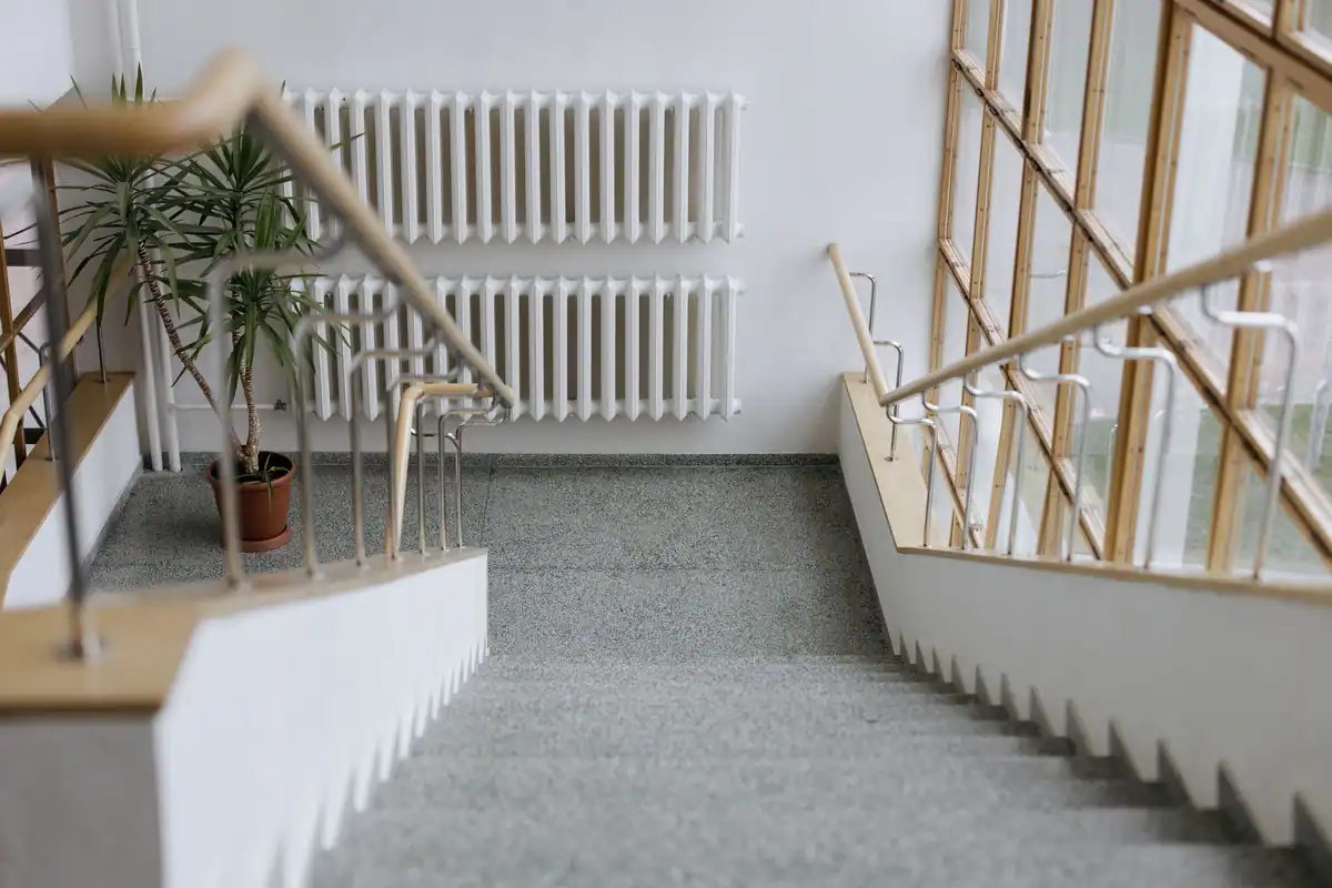 Casa scării modernă cu balustradă și ferestre mari, parte din spațiile comune