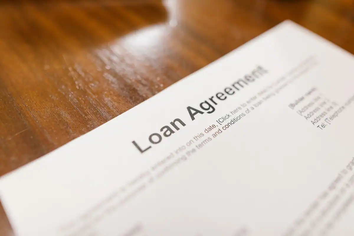 Contract de credit așezat pe o masă de lemn, privit de aproape