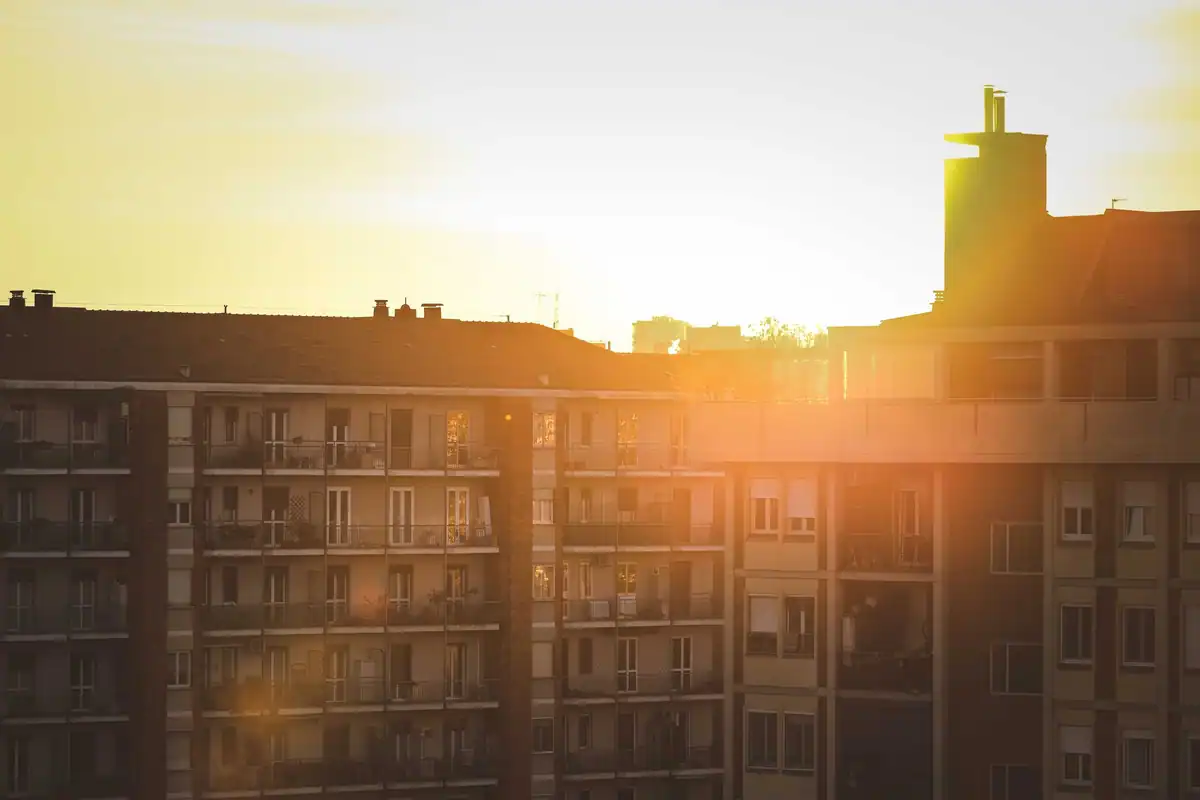 Răsăritul de soare care luminează fațadele unor blocuri de locuințe