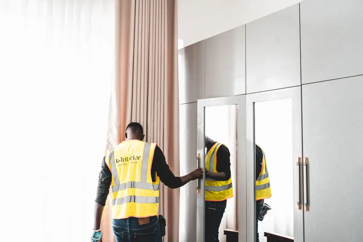 Muncitor de întreținere care verifică oglinda unui dulap într-un apartament